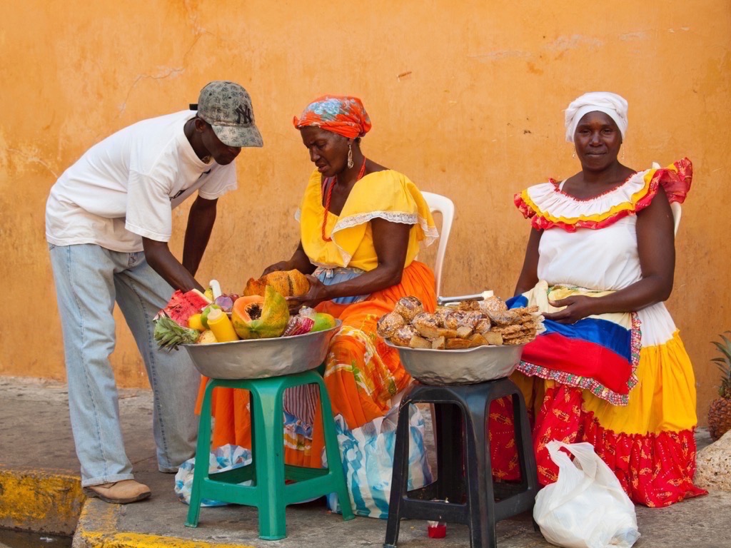在拉丁美洲哥伦比亚的卡塔赫纳，当地小贩在街边出售水果和烘焙食品