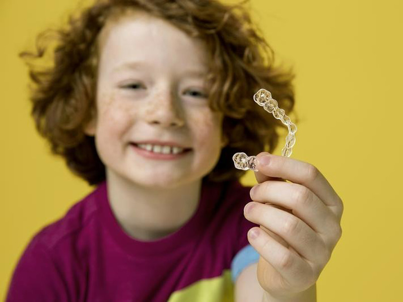 儿童拿着一个校正器为网络文章儿童牙齿和牙套